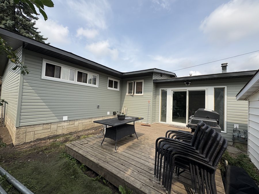 Rear of home with siding over a stone half-wall base